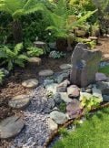 window stone water feature in a rockery border