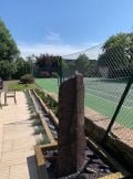 slate monolith water feature between patio and tennis court