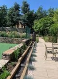 slate monolith water feature next to a tennis court